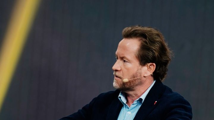 Markus Miller im Gespräch auf einer Bühne, mit Headset-Mikrofon – Video „In Bitcoin wie Trust“ auf YouTube