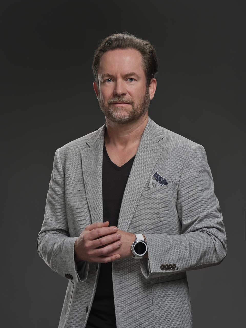Markus Miller im grauen Sakko vor neutralem Studiohintergrund